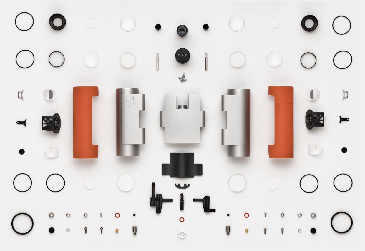 A tabletop view with binoculars disassembled into their individual parts