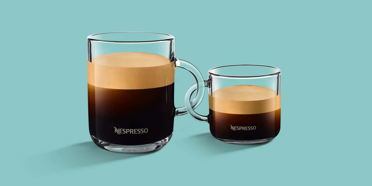 Two different sized glasses with Nespresso, the handles of which are interlocked