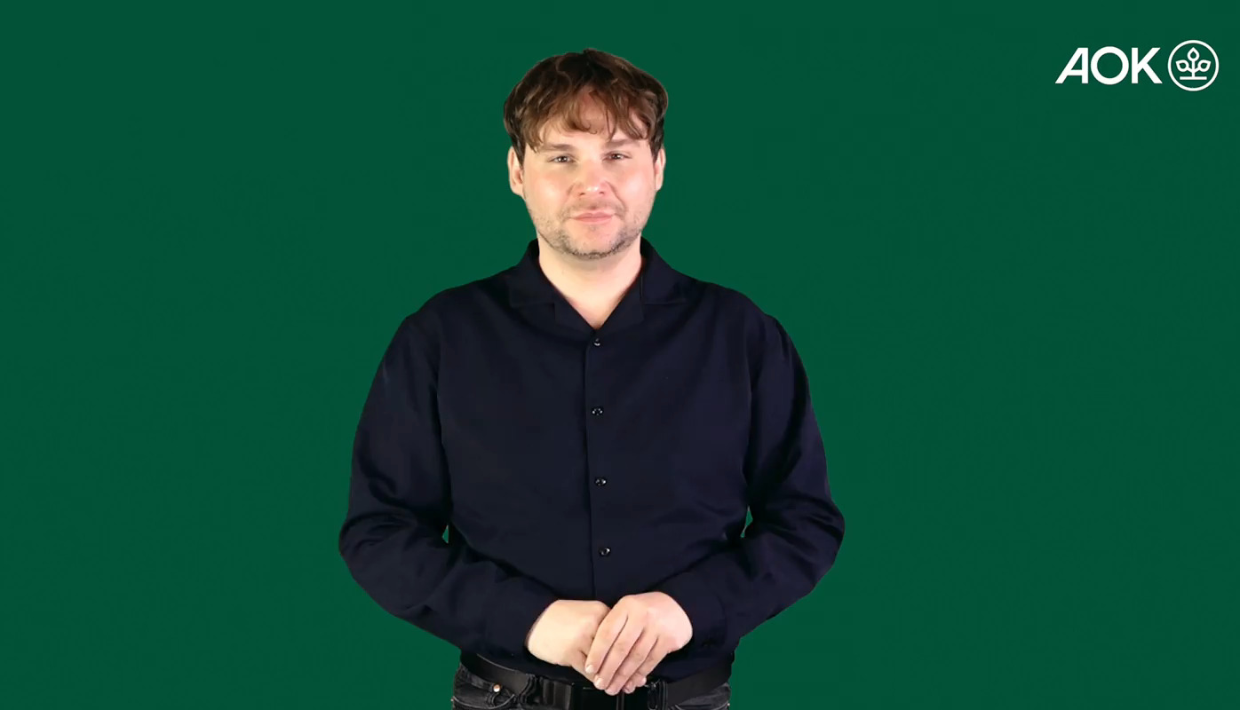 Video eines Gebärdendolmetschers vor grünem Hintergrund, der in Gebärdensprache kommuniziert.