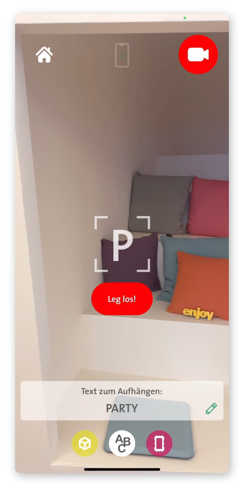 Ein Handyvideo mit dem ein Raum gefilmt wird. In dem Video wird mit der See you-App in den Raum eine Augmented Reality-Animation erstellt, die aus Luftballon-Buchstaben das Wort “Party” darstellt.