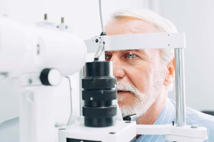 The eyes of an elderly man are examined by an eye doctor